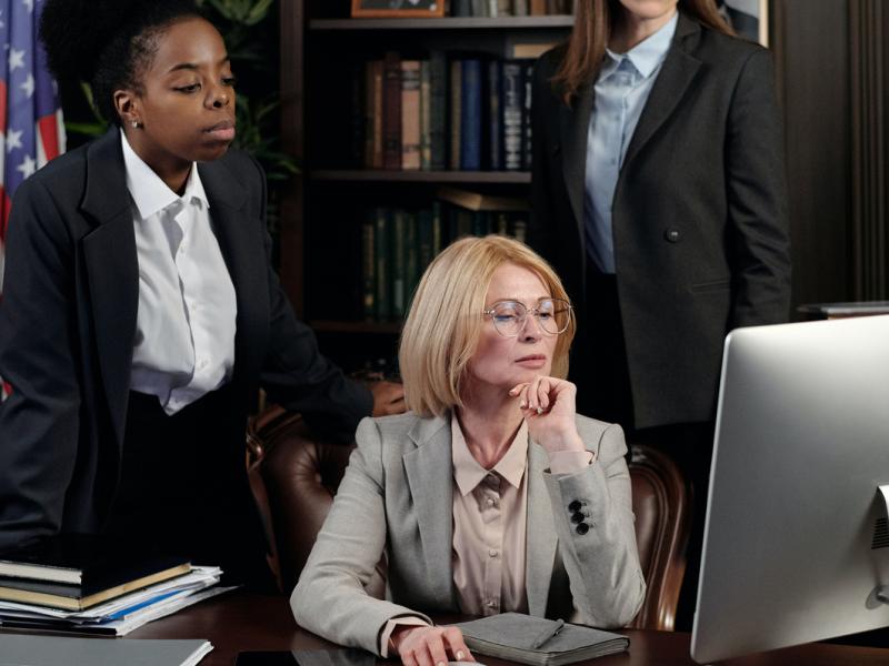 Lawyers gathered around a computer desk